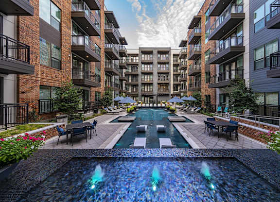 A fountain in the middle of a courtyard surrounded by buildings.