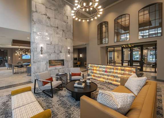 A modern living room with a stone fireplace and a large sectional sofa.