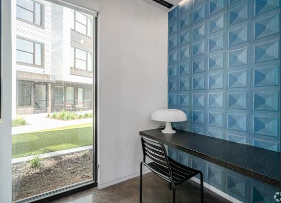 a desk with a chair in a room with a window
