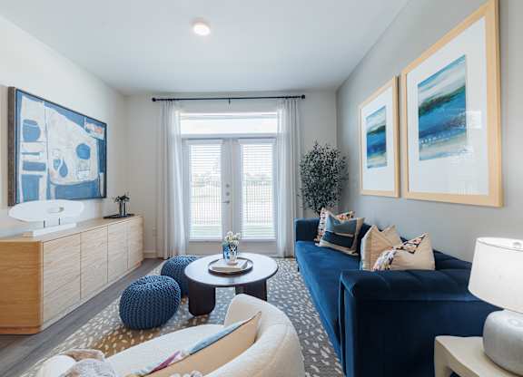A living room with a blue couch and a wooden cabinet.