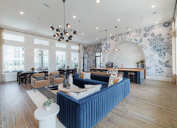 A living room with a blue sofa and wooden floors.