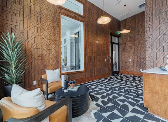 A reception area with a wooden wall and a black and white floor.