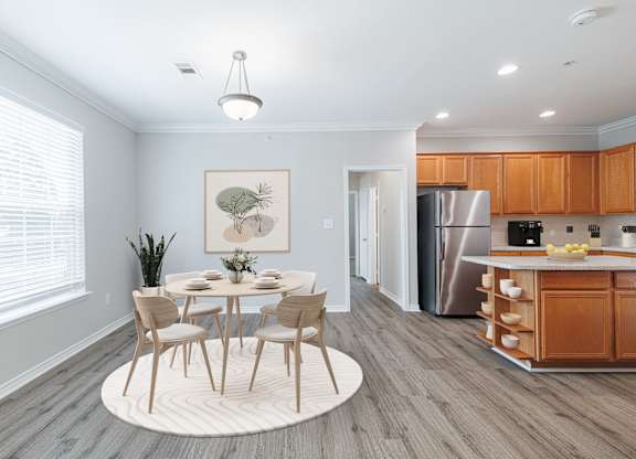 A dining room with a table set for four and a kitchen in the background.