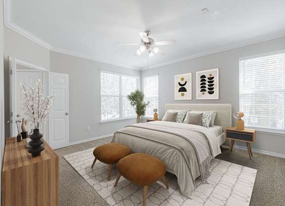 A bedroom with a large bed, a wooden table, and a ceiling fan.