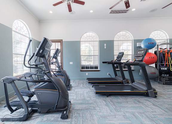 A gym with treadmills and elliptical machines.