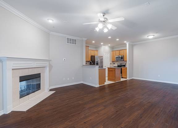 A living room with a fireplace and wooden floors.
