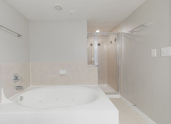 A white bathroom with a large tub and a walk-in shower.