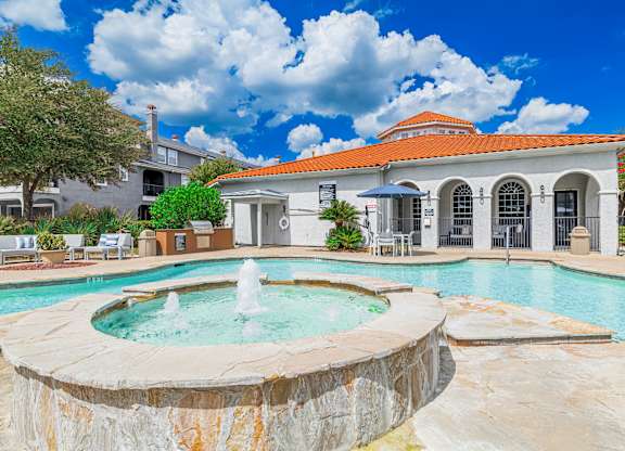 A pool with a fountain in the middle of it.