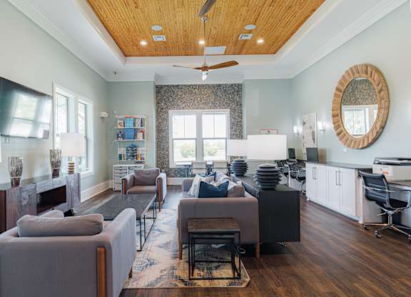 A living room with a grey couch and a wooden floor.