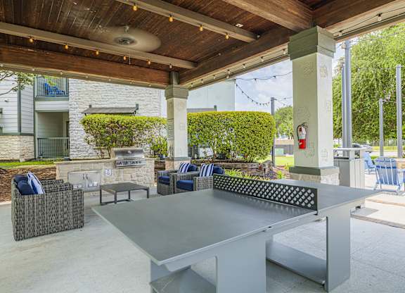 A patio with a table and chairs under a roof.