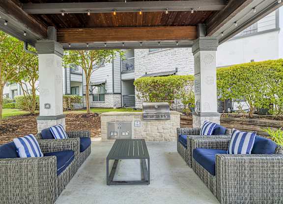 A patio with a table and chairs under a roof.