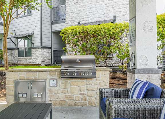 A stone wall with a grill on top of it.