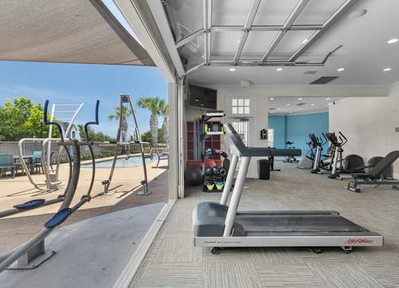 A treadmill is in the middle of a room with exercise equipment.