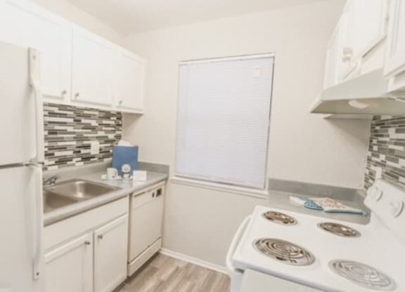 a white kitchen with a stove and a refrigerator
