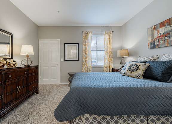 a bedroom with a bed and a dresser and a window