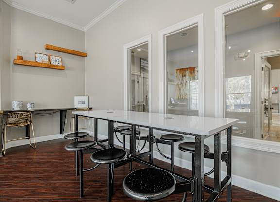 A dining room with a white table and black stools.