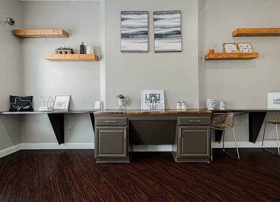 A room with a desk and chairs with a grey and black theme.