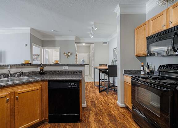 a kitchen with an island and a stove top oven and a sink