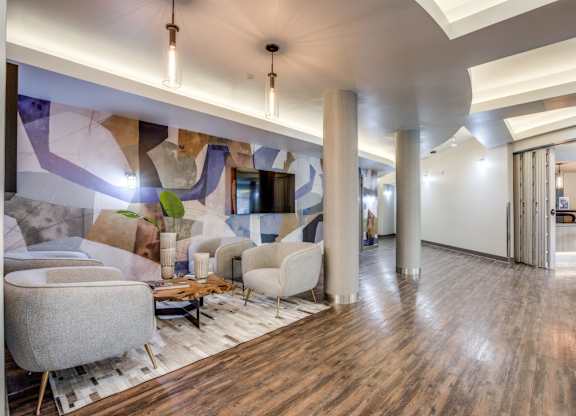 A modern living room with a wooden floor and a large mural on the wall.