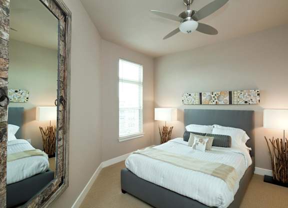 A bedroom with a large bed and a ceiling fan.