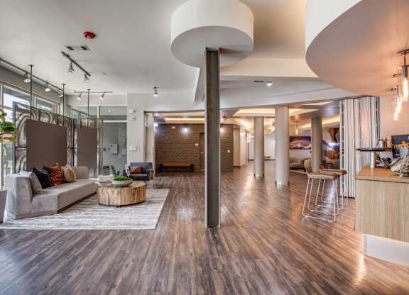A modern living room with a curved white ceiling and a long wooden floor.