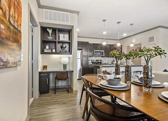 A modern kitchen with a dining table set for two.