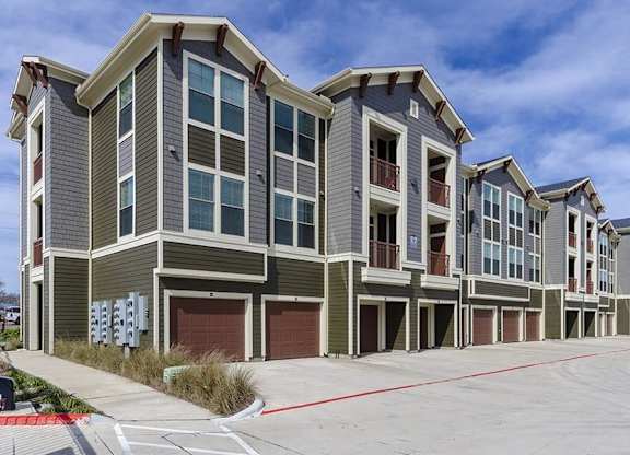 A row of modern townhouses with garages and balconies.