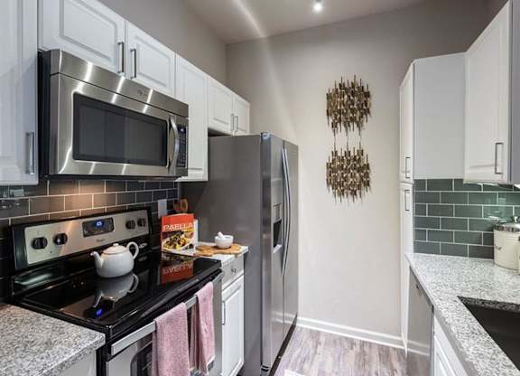 a kitchen with a stainless steel refrigerator and microwave
