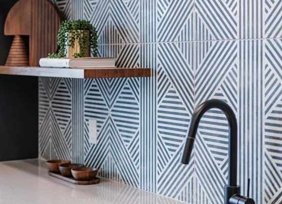 A kitchen with a sink and a patterned wallpaper.