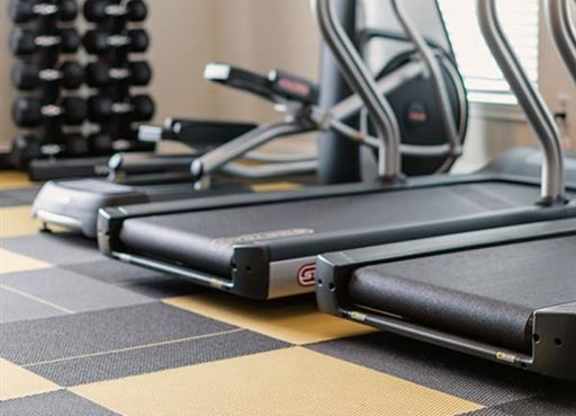 A treadmill and a stationary bike are on a checkered floor.