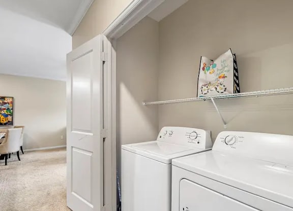 A white washing machine and dryer in a laundry room.