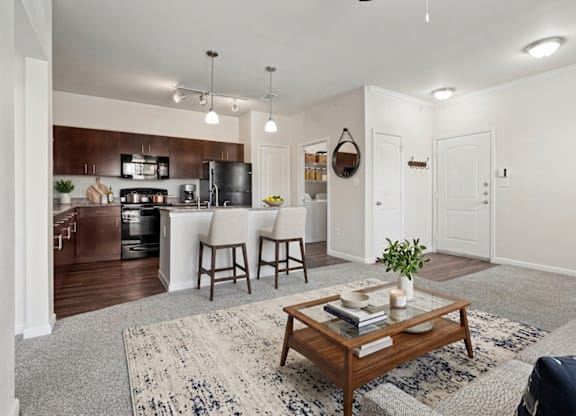 A modern kitchen with a dining area and a living room.