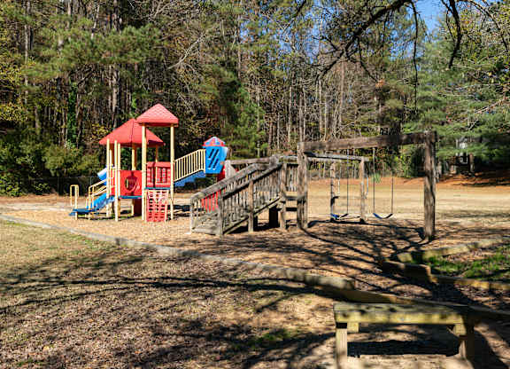 a playground in a park with trees in the background