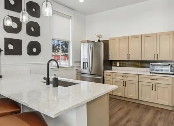 A kitchen with a white countertop and wooden cabinets.