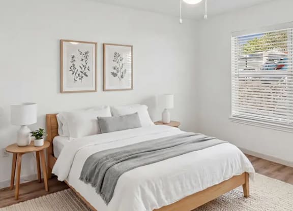 A bedroom with a large bed and two framed pictures on the wall.
