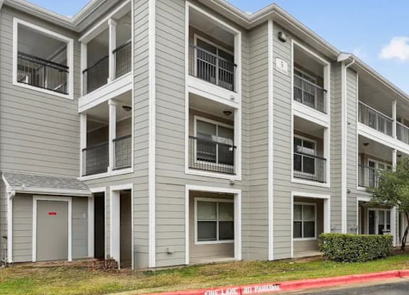 A multi-story apartment building with balconies and doors.
