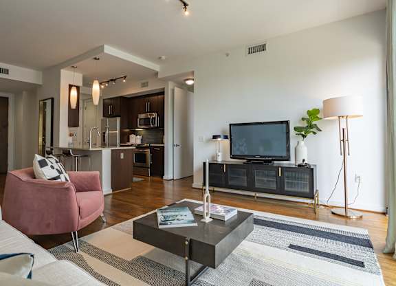 A modern living room with a pink armchair and a black coffee table.