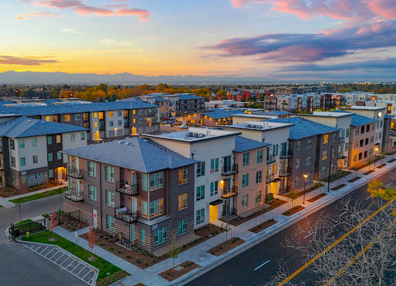 A sunset view of a residential area with apartment buildings.
