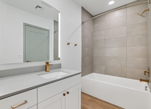a bathroom with a sink and a tub and a mirror