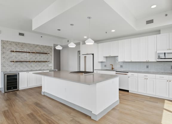 a large white kitchen with a large island and white cabinets