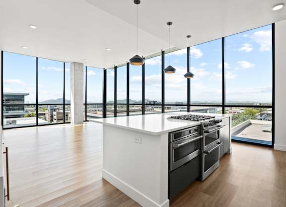 A modern kitchen with a large island and stainless steel appliances.