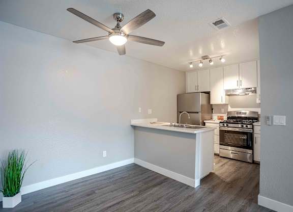 an open kitchen and living room with a ceiling fan