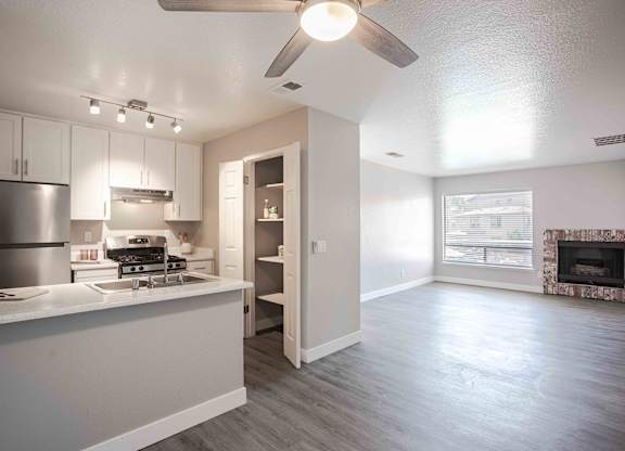 an open kitchen and living room with a ceiling fan