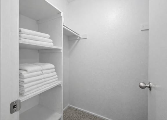 A white bathroom with a towel rack and towels.