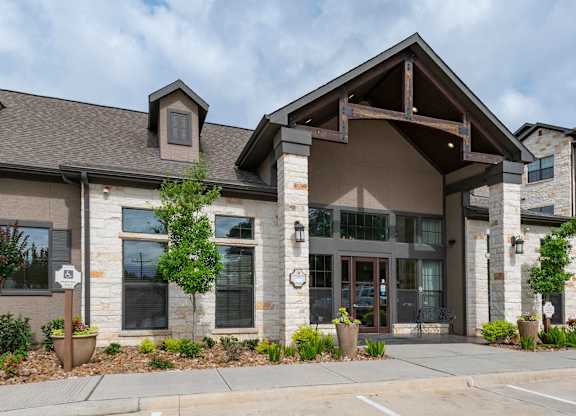 A modern building with a stone facade and a large glass entrance.