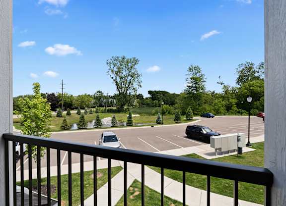 A parking lot with cars and trees in the distance.