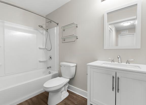 A white bathroom with a toilet, sink, and bathtub.