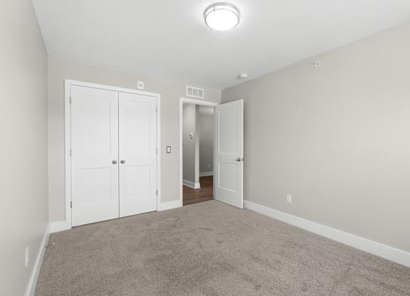 A room with a carpeted floor and white walls.