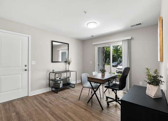 A room with a table and chairs and a mirror on the wall.