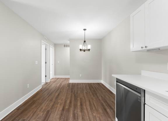 A kitchen with a dishwasher and wooden floors.